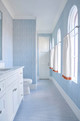 Bathroom interior by Jenkins Interiors featuring Downey wallpaper in Sky by Kate Blee; hand-drawn linear design in soft blue tones creates a calm, contemporary look.